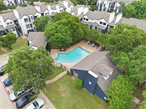 A bird's eye view of a residential area with a swimming pool.