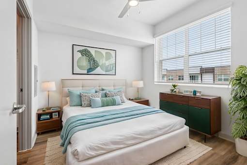 A bedroom with a large bed and a ceiling fan.
