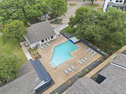 A backyard with a pool and sun loungers.