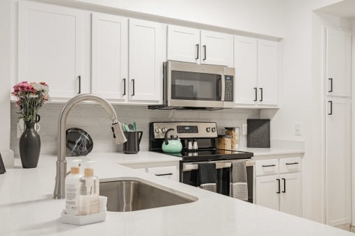 a modern kitchen with white cabinets and a sink