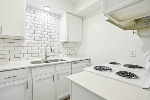 A white kitchen with a stove top oven.