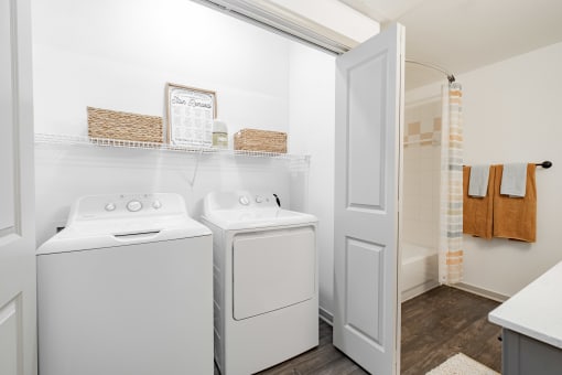 a washer and dryer in a laundry room with a door to the bathroom