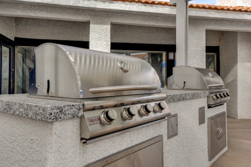 a stainless steel bbq grill is set up in the backyard of a home