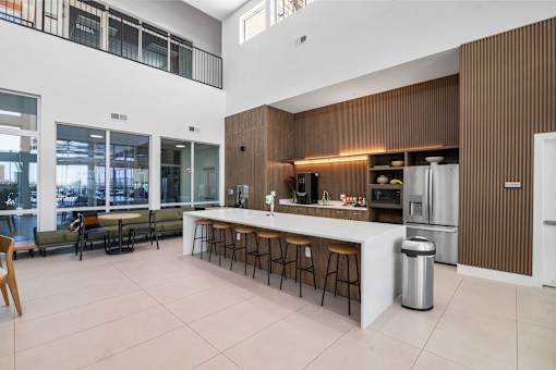 A modern kitchen with a bar area and a view of the city.