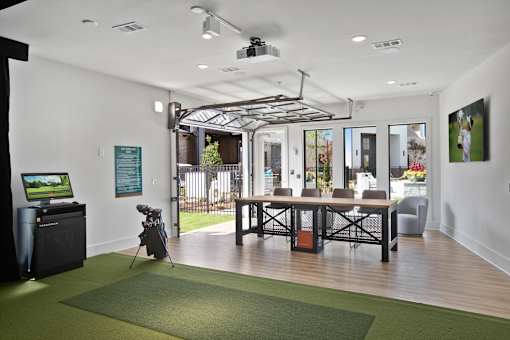A room with a green carpet and a ceiling fan.