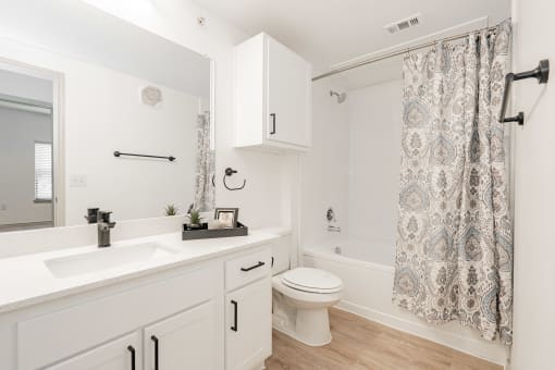 a bathroom with a shower and a toilet and a sink