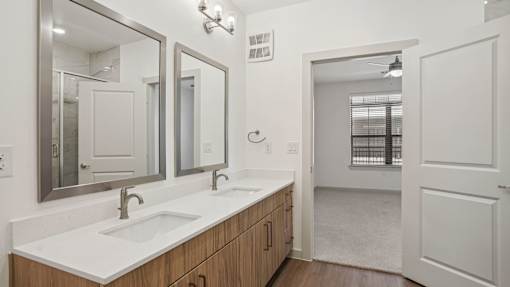 A bathroom with a white sink and mirrors.