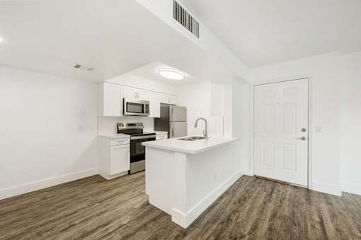 a white kitchen with a white counter top and