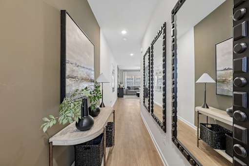 A long hallway with a table and mirrors on the wall.