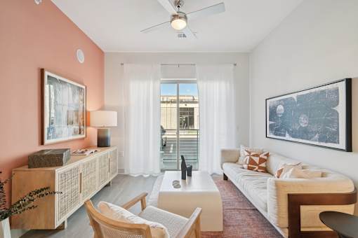 A living room with a white couch, a wooden coffee table, and a ceiling fan.