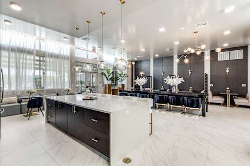 A modern kitchen with a large island and a dining area.