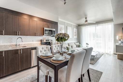 A modern kitchen with a dining table set for two.