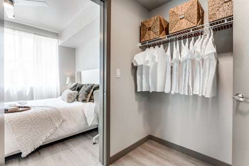 A white bedroom with a white bed and a white wardrobe.