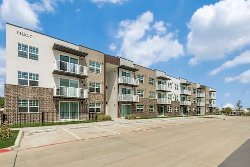Apartment building BLDG 2 with a parking lot in front.