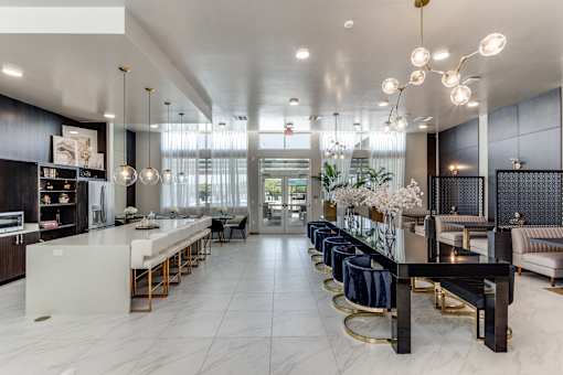 A modern kitchen with a long white island and bar stools.