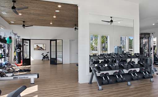 A gym with a variety of equipment including a rowing machine.