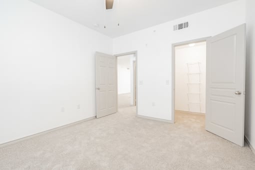 a bedroom with white walls and white doors and a carpeted floor