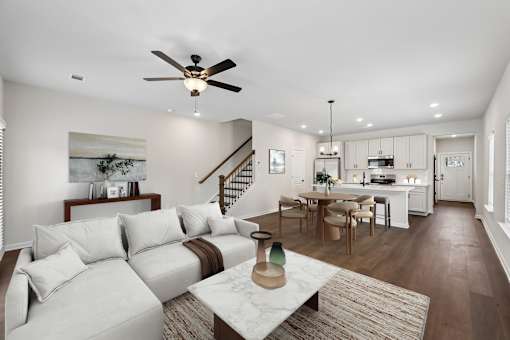 A living room with a white couch and a rug.