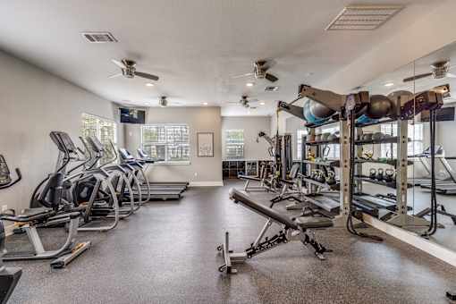 A spacious gym with treadmills, elliptical machines, and weightlifting equipment.