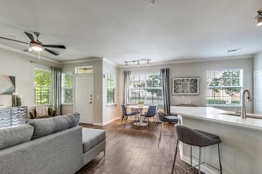 A living room with a grey couch and a bar area.