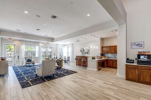 A spacious living room with a kitchen area in the background.