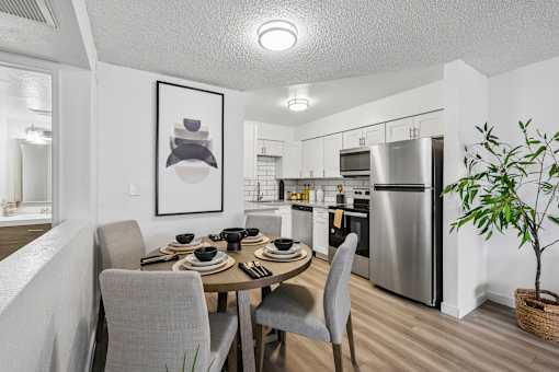 A modern kitchen with a dining table set for four.
