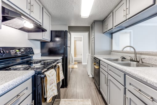 a kitchen with white cabinets and black appliances and a sink