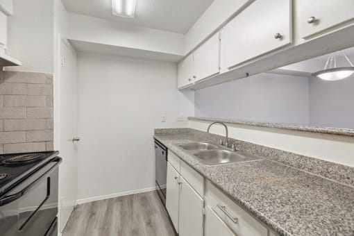 the kitchen has granite counter tops and a stainless steel sink