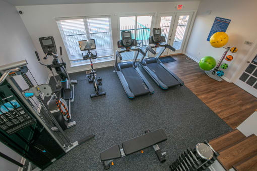 a gym with cardio equipment and weights in an apartment