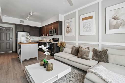 A modern living room with a grey sofa and a white coffee table.