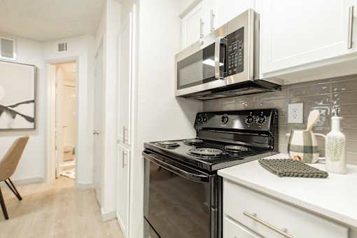 A modern kitchen with a black stove top oven and microwave above it.
