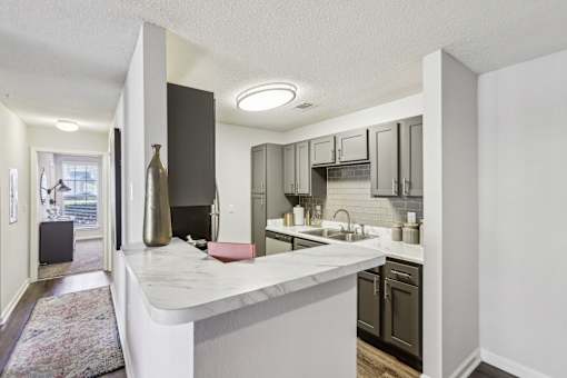 A kitchen with a white counter top and a sink.