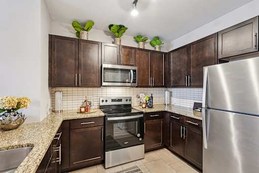 A kitchen with brown cabinets and a stainless steel refrigerator.
