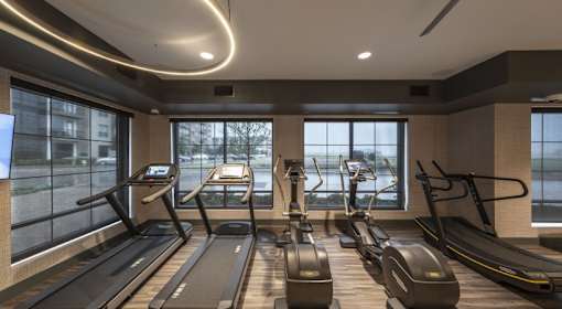 A gym with treadmills and elliptical machines.