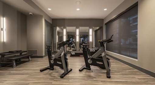 A gym with a treadmill and a bench.