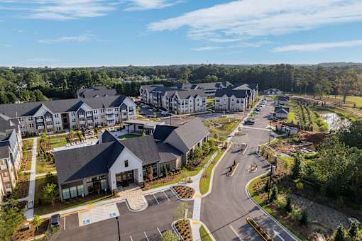 A large, well-maintained residential complex with multiple buildings and a spacious parking lot.