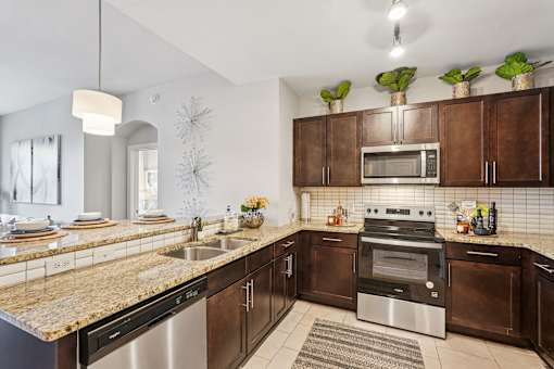 A modern kitchen with brown cabinets and stainless steel appliances.