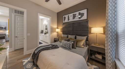 A bedroom with a large bed and a ceiling fan.