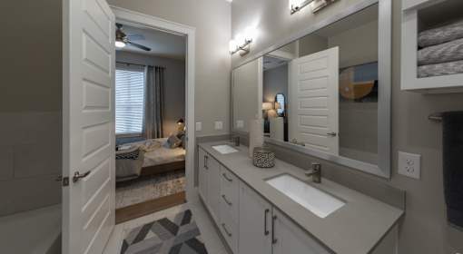 A bathroom with a white sink and a mirror.