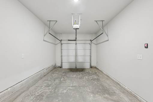 A large empty room with a concrete floor and white walls.