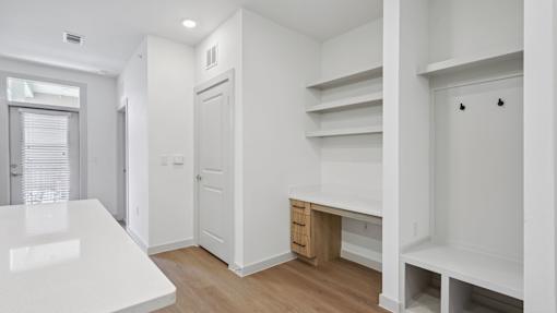 A white room with a desk and a window.