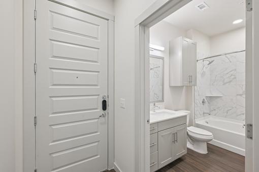 A white bathroom with a toilet, sink, and bathtub.