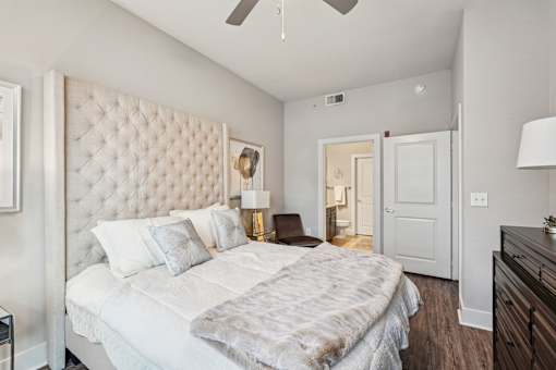 A bedroom with a large bed and a ceiling fan.