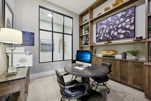 A modern office with a round table and a computer on it.