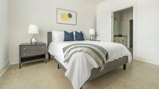 A bedroom with a bed, nightstand, and lamp.