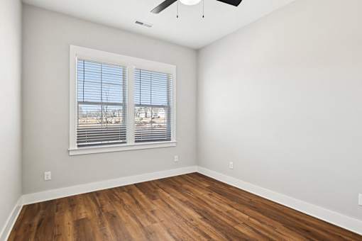 A room with a window and wooden flooring.