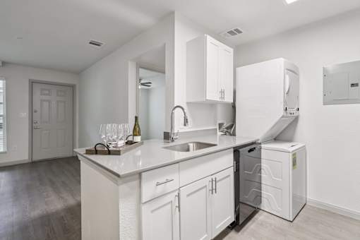 A kitchen with white cabinets and a white counter top.