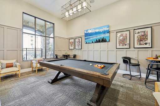 A room with a pool table and a television playing a nature scene.