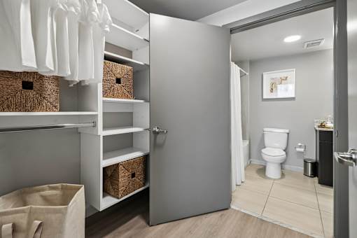 A bathroom with a toilet, a sink, and a laundry area.