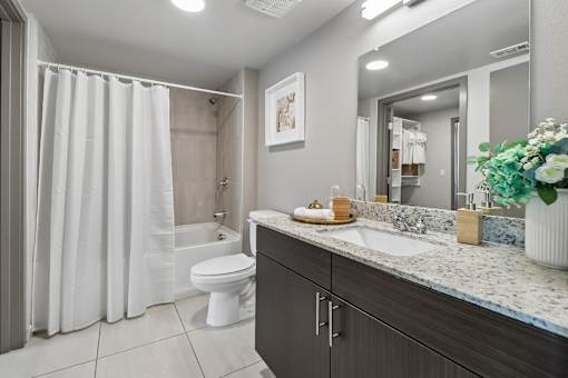 A modern bathroom with a white toilet and a shower curtain.